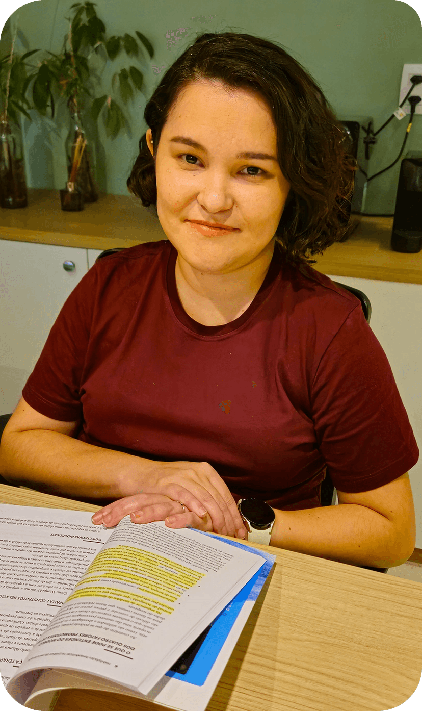 Psicóloga Existencialista Tainá Marcinichen em sentada seu consultório. Terapeuta na Freguesia de Jacarepaguá.